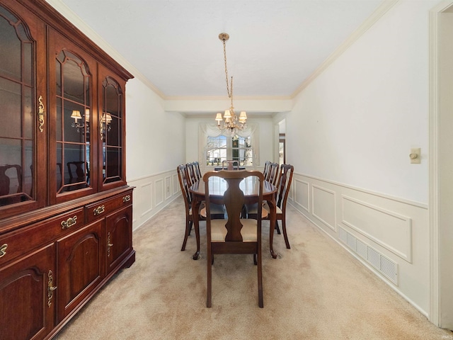 dining area with light carpet, crown molding, and an inviting chandelier