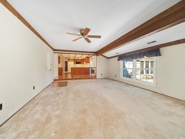 unfurnished living room featuring ceiling fan, light carpet, and beam ceiling