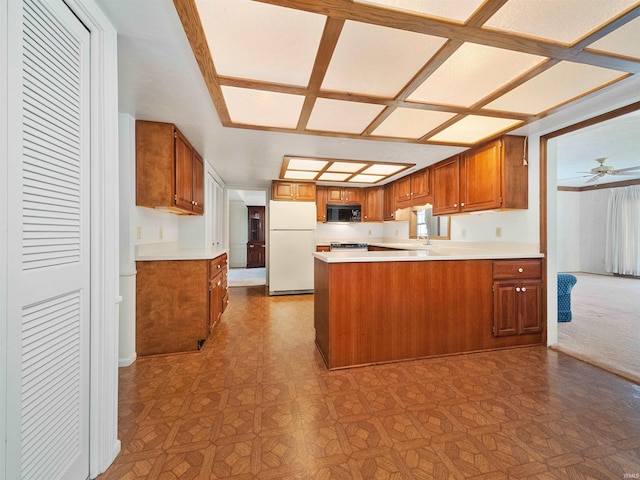 kitchen featuring sink, white refrigerator, stove, ceiling fan, and kitchen peninsula