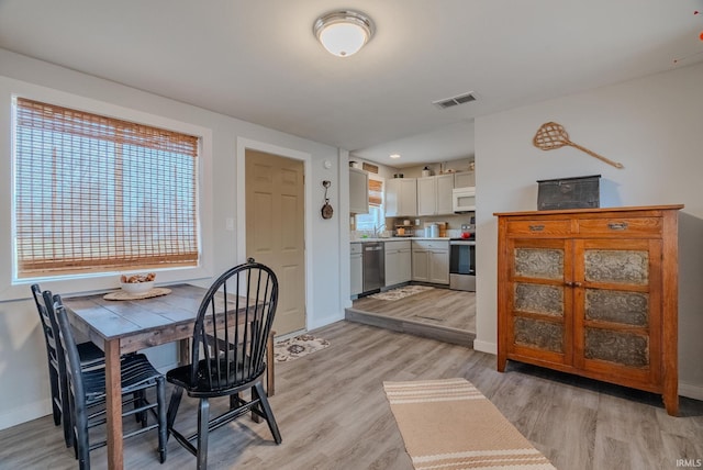 dining area featuring sink and light hardwood / wood-style flooring