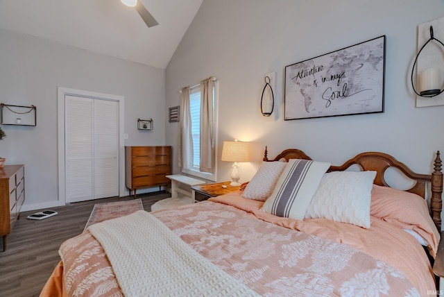 bedroom featuring ceiling fan, dark hardwood / wood-style flooring, high vaulted ceiling, and a closet