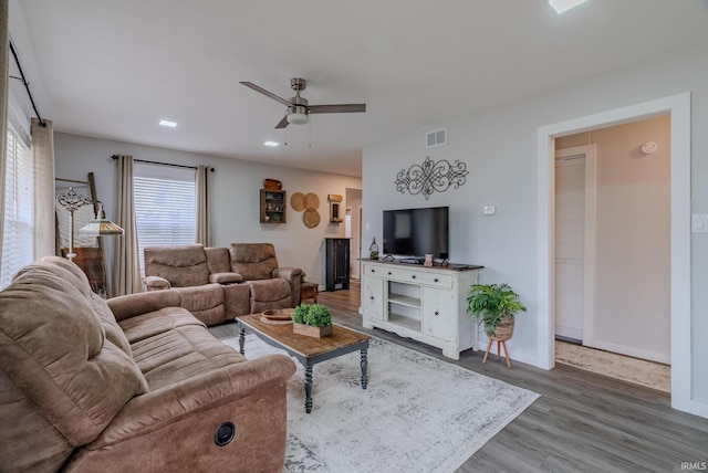 living room featuring wood-type flooring and ceiling fan