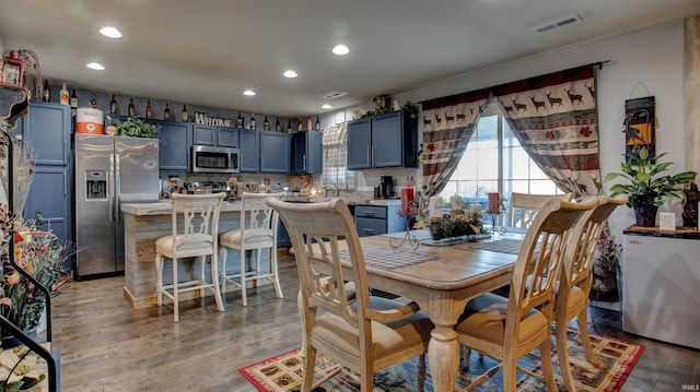 dining space with sink and light hardwood / wood-style flooring