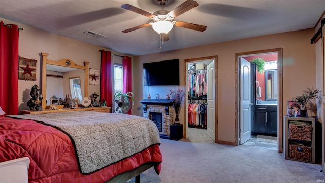 carpeted bedroom featuring ensuite bath, a wall mounted air conditioner, a spacious closet, a closet, and ceiling fan