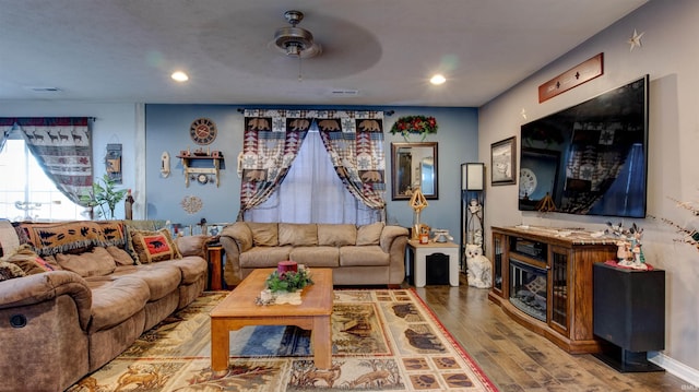 living room featuring hardwood / wood-style floors and ceiling fan