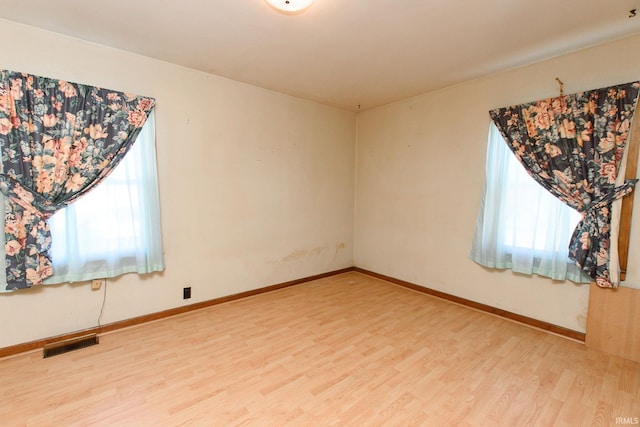 spare room with hardwood / wood-style flooring and a healthy amount of sunlight