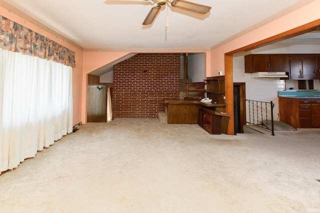 carpeted living room featuring crown molding, ceiling fan, and brick wall