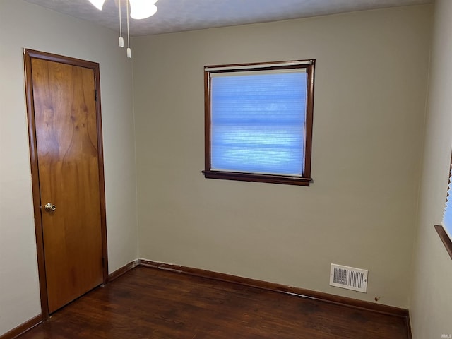 unfurnished room with dark wood-type flooring