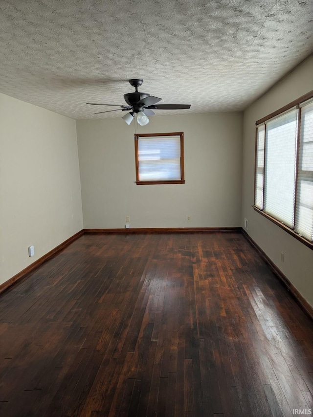 empty room with ceiling fan, dark hardwood / wood-style floors, and a textured ceiling