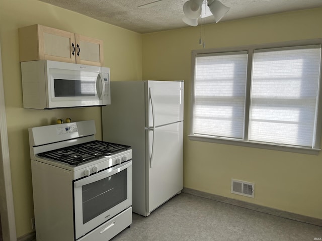 kitchen featuring ceiling fan, light brown cabinets, a textured ceiling, and white appliances