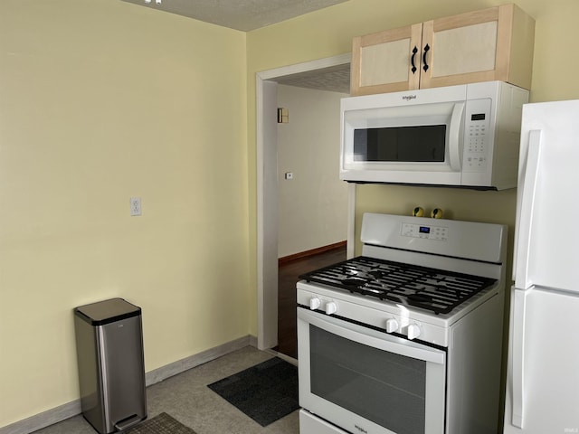 kitchen with white appliances and light brown cabinetry