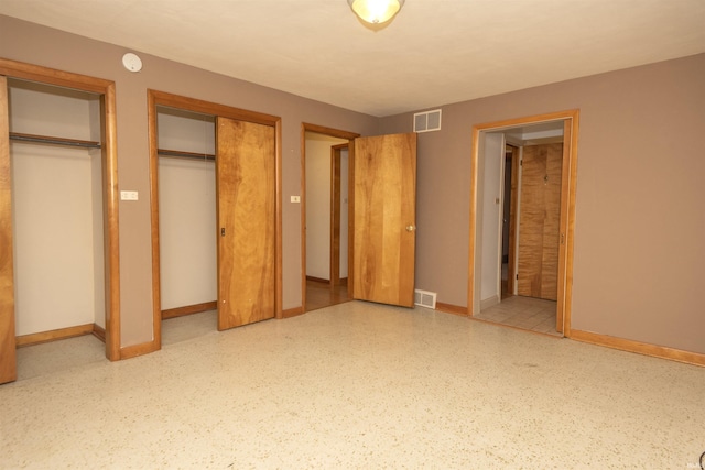 unfurnished bedroom featuring multiple closets