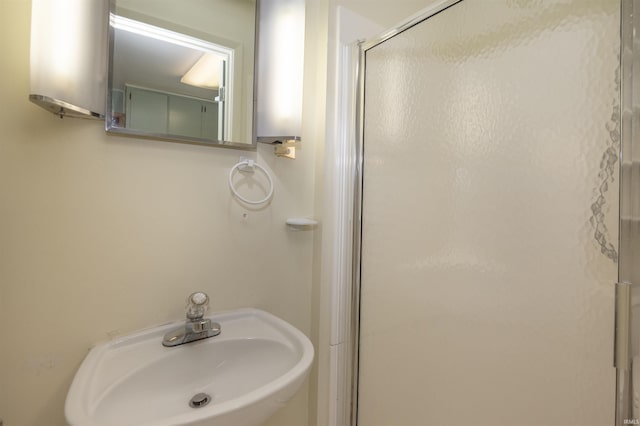 bathroom with sink and a shower with shower door