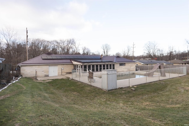 rear view of house featuring a yard, a fenced in pool, and a patio area