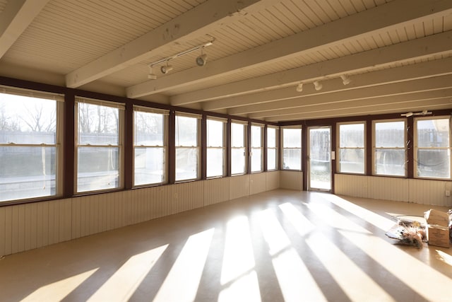 unfurnished sunroom featuring track lighting and beam ceiling