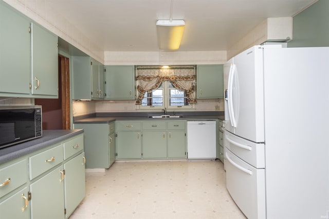 kitchen featuring white appliances, sink, and green cabinetry