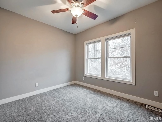 carpeted spare room featuring ceiling fan