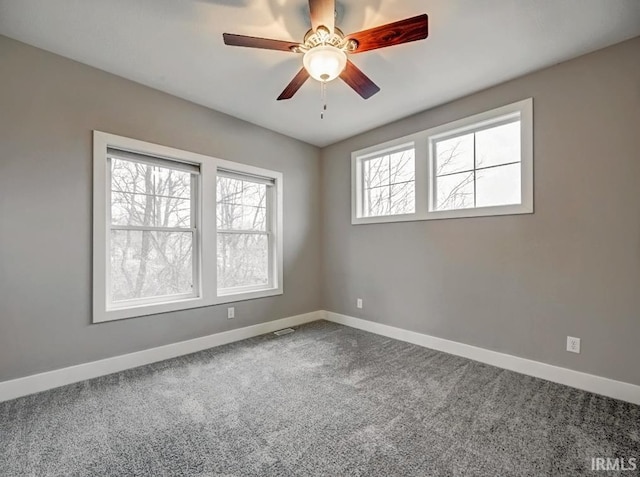 unfurnished room with ceiling fan and carpet