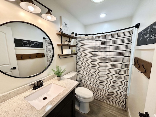 bathroom featuring vanity, hardwood / wood-style flooring, curtained shower, and toilet