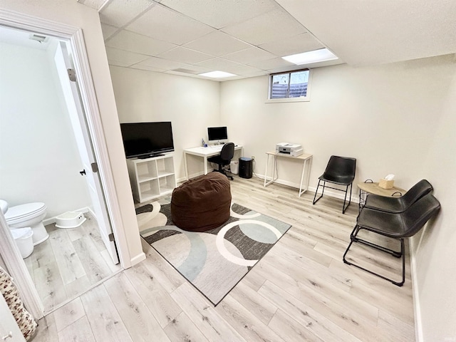 interior space with a paneled ceiling and light hardwood / wood-style floors