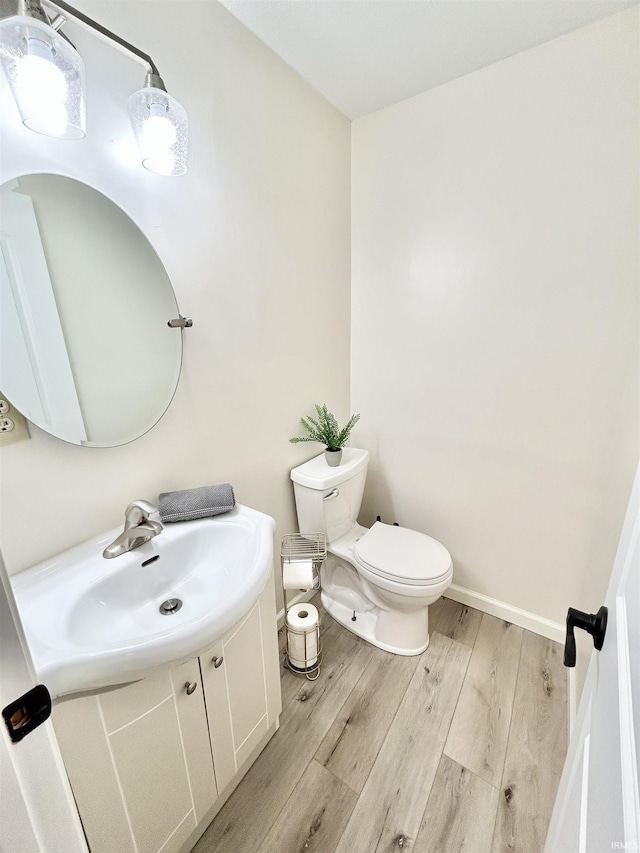 bathroom featuring vanity, hardwood / wood-style flooring, and toilet