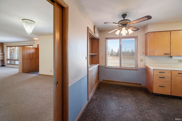 kitchen with dark carpet, a baseboard radiator, and ceiling fan with notable chandelier