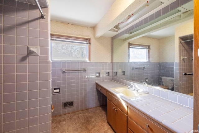 bathroom featuring beamed ceiling, vanity, tile walls, and tile patterned floors