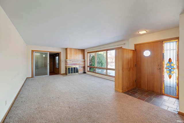 entryway with dark colored carpet and a brick fireplace