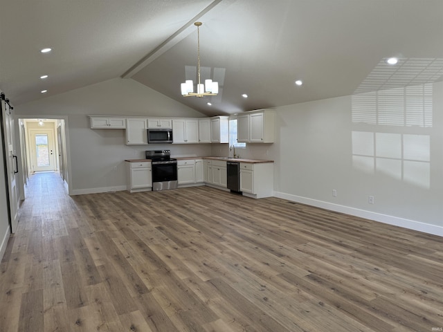 kitchen featuring a notable chandelier, a sink, light wood-style floors, appliances with stainless steel finishes, and baseboards