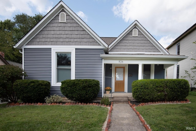 bungalow featuring covered porch and a front yard