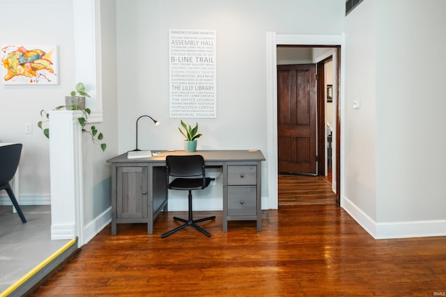 home office with dark hardwood / wood-style floors