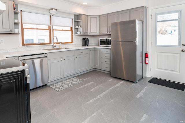 kitchen featuring a healthy amount of sunlight, appliances with stainless steel finishes, sink, and gray cabinetry