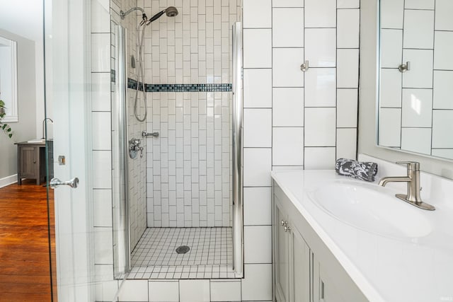 bathroom featuring vanity and a shower with door