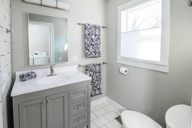 bathroom featuring washing machine and dryer, vanity, tile patterned flooring, and toilet