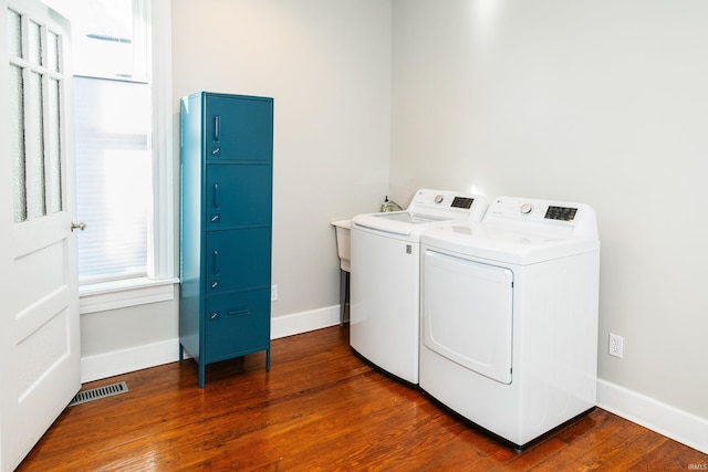 laundry area with dark wood-type flooring and washer and dryer