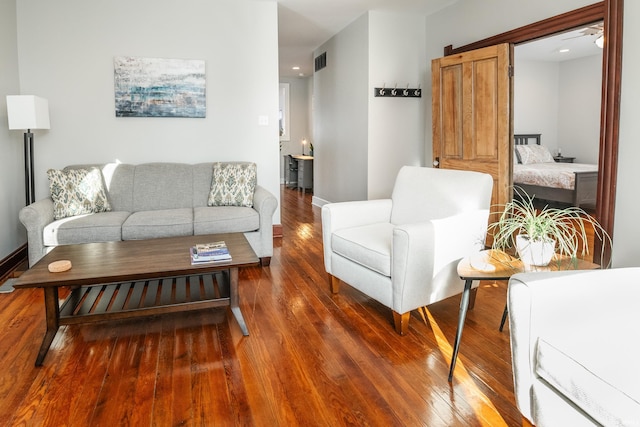 living room featuring a barn door and dark hardwood / wood-style floors