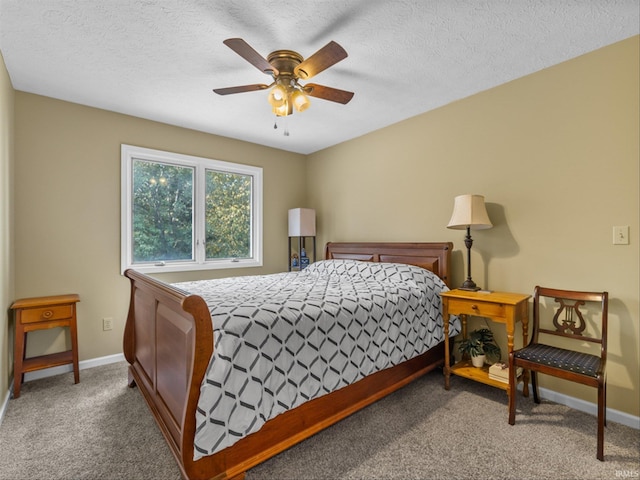 bedroom with ceiling fan, carpet, and a textured ceiling