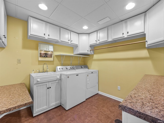 laundry room with cabinets, sink, independent washer and dryer, and dark tile patterned flooring