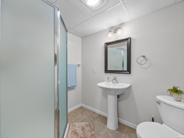 bathroom with toilet, a shower with shower door, sink, tile patterned flooring, and a drop ceiling