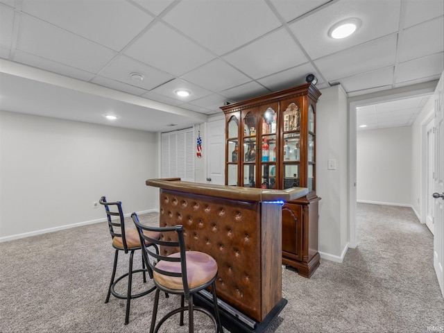 bar featuring light carpet and a paneled ceiling