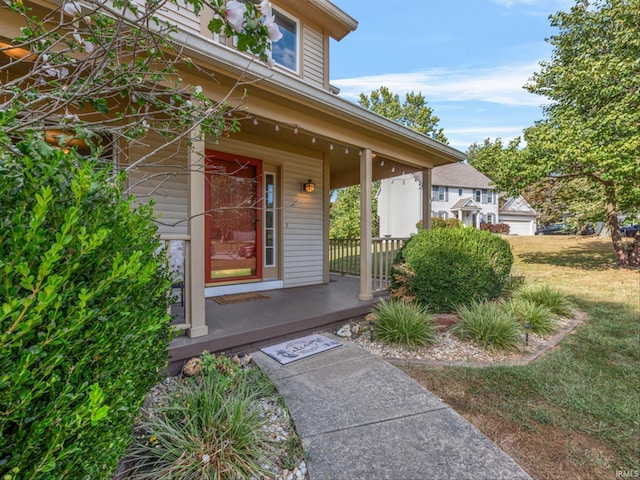 doorway to property with a yard and covered porch