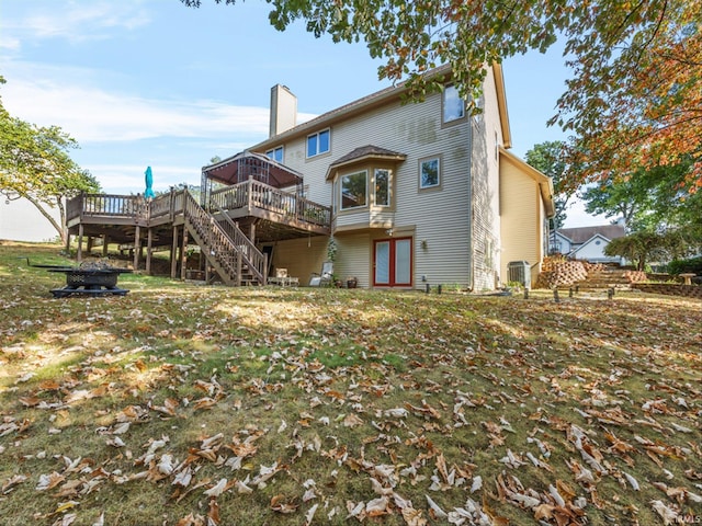 back of house with a deck, a lawn, and central air condition unit