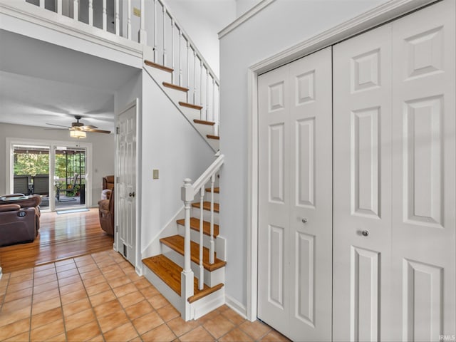 stairway featuring ceiling fan and tile patterned flooring