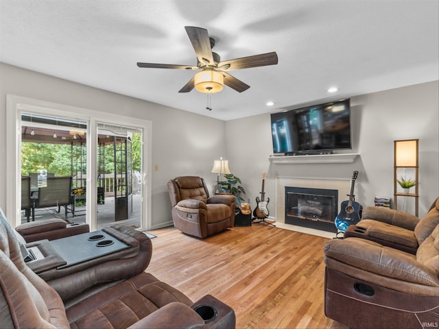 living room featuring light hardwood / wood-style flooring and ceiling fan