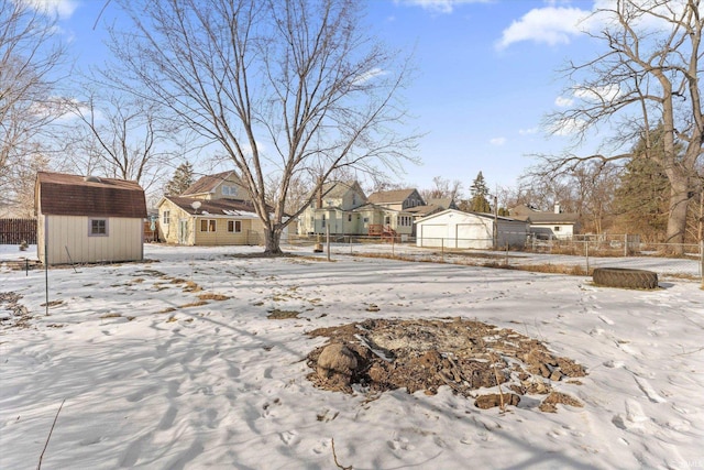 snowy yard with a storage shed