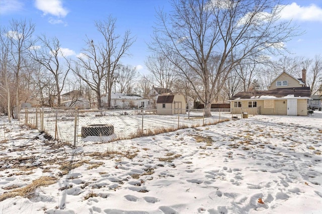 yard layered in snow featuring a shed