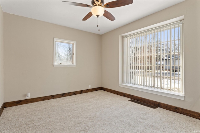 carpeted spare room featuring ceiling fan