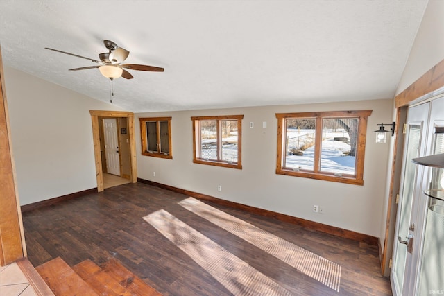 spare room with ceiling fan, lofted ceiling, a textured ceiling, and dark hardwood / wood-style flooring