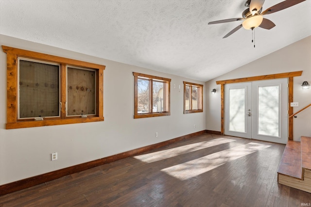 unfurnished room featuring dark wood-type flooring, vaulted ceiling, french doors, and plenty of natural light