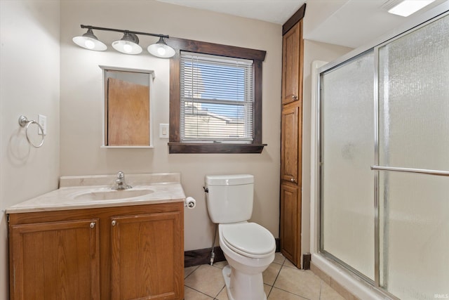 bathroom featuring tile patterned flooring, vanity, a shower with door, and toilet